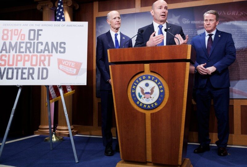 Three men in suits stand at a U.S. Senate podium. To their left is a sign reading 81% of Americans support Voter ID with Vote and Federal stickers. Cuccinelli: SAVE Act Debate Marks Major Step Forward as Senate Pauses for Easter Recess.